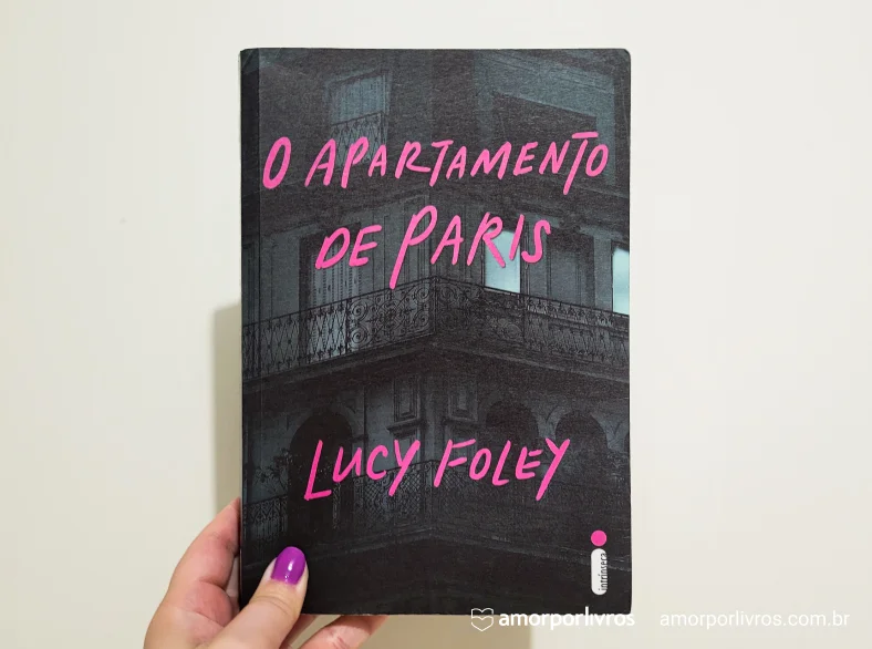 Mão segurando o livro O Apartamento de Paris